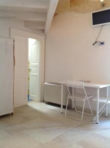 a room with a table and a chair and a door at Cantaluna B&B in Polignano a Mare