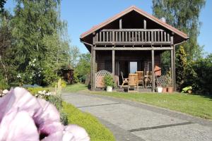 a small cabin with a porch and a garden at Lovely holiday home in Kolczewo with a fireplace and big garden in Kołczewo