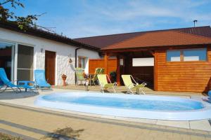 a swimming pool with chairs and a house at Terraced house with pool and sauna, Sieciemin in Sieciemin