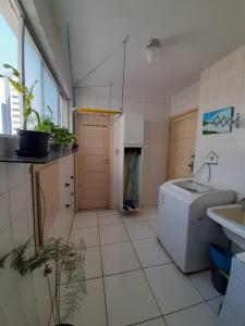 a bathroom with a washing machine and a sink at Apt Pituba in Salvador