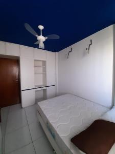 a room with a bed with a ceiling fan at Apt Pituba in Salvador