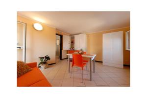 a living room with a couch and a table with orange chairs at 4Canti Case Vacanze in Castellammare del Golfo