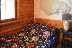 a bed in a room with a flower patterned blanket at holiday home, Junoszyno in Junoszyno