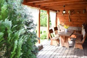 holiday home, Junoszyno في Junoszyno: شرفة كابينة خشبية مع طاولة خشبية