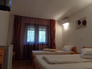 una camera d'albergo con due letti e una finestra di Pensiunea Orion a Costinesti
