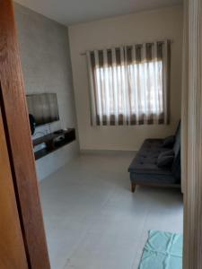 ein Wohnzimmer mit einer Couch und einem Fenster in der Unterkunft Casa de praia no Condomínio Guaratiba, Prado-BA in Prado