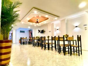 a dining room with tables and chairs and a plant at Hotel Eterna Primavera in Medellín