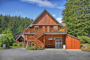a large wooden house with a large deck at Wild Coast Wilderness Resort in Port Renfrew