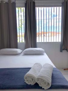 a bedroom with two beds with towels on the bed at Pousada Center in Barreirinhas