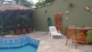 a patio with a table and chairs and a small pool at POUSADA CASA DIAMANTe in Cabo Frio