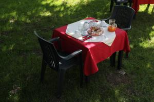 a table with a red table cloth on a table sidx sidx sidx at Rifugio Del Pettirosso in Pescasseroli