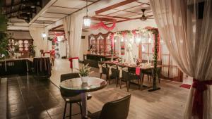 a restaurant with a table and chairs and a mirror at Raintree Boutique Villa & Gallery in Yogyakarta