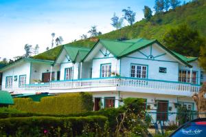 a large white house with a green roof at Blue Moon Hotel in Nuwara Eliya