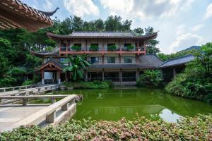 um edifício com um lago em frente em Guilin Yi Characteristic Hotel CoLTD em Guilin
