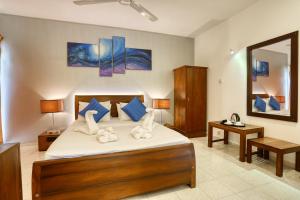 een slaapkamer met een groot bed en een spiegel bij Mount Marina Villas in Galle