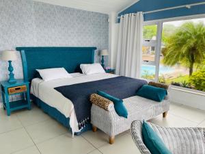 ein Schlafzimmer mit einem blauen Bett mit einem Stuhl und einem Fenster in der Unterkunft ThE LaZy ShArK in Freeland Park
