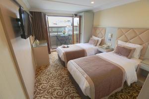a hotel room with two beds and a television at Alpinn Hotel Istanbul in Istanbul +176 photos