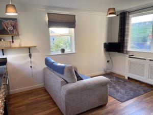 a living room with a couch and a television at Holme Valley Vista, Holmfirth in Holmfirth