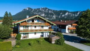 una imagen de una casa con montañas en el fondo en Aparthotel Chiemgaufuchs, en Inzell