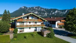 an image of a house with mountains in the background at Aparthotel Chiemgaufuchs in Inzell