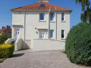 uma casa branca com um telhado vermelho em Haig Apartments em Kirkcaldy