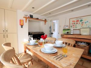a dining room with a wooden table and chairs at Bow Cottage in East Portlemouth