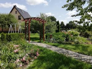 a garden with an arbor in front of a house at Kleiner Bungalow im Grünen in Radeberg