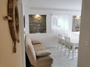 a living room with a couch and a table with chairs at APARTMA KANTINA in Ankaran