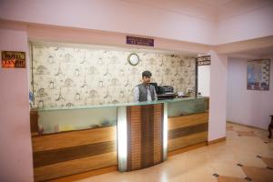 a man standing at a counter in a restaurant at Hotel Tanish in Madgaon
