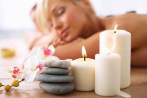 una mujer tumbada en una mesa junto a las velas en Bale Solah Lombok Holiday Resort, en Senggigi 