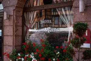 
a sign in front of a building with flowers on it at Hotel Saint-Martin in Colmar
