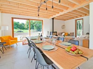 Ecologis Hamoir في Hamoir: غرفة طعام مع طاولة وكراسي خشبية كبيرة