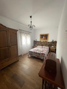 a bedroom with a bed and a dresser and a table at Casa Aguascalientes in Los Albaricoques