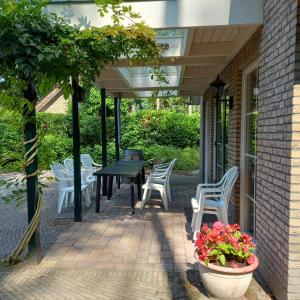 Vakantiehuis met sauna en jacuzzie في لونتيرين: فناء مع طاولة سوداء وكراسي بيضاء