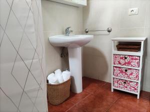 a bathroom with a sink and a basket of towels at Casa del Cu bano B- Biosphere Reserve in Santa Cruz de Tenerife