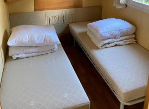 2 camas con almohadas en una habitación pequeña en Breitner Chalet op de Schatberg en Sevenum