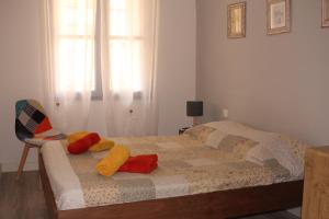 Un dormitorio con una cama con almohadas de colores. en Chez Marie Louise, en Pézenas