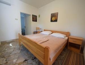 a bedroom with a large bed with two pillows at Apartments Skender in Vantačići