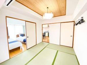 川口市にあるホテル西川口ウィークリーのベッドルーム1室(ガラスドア、ベッド1台付)