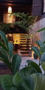 una habitación con muchas plantas verdes y una mesa en Inn Oon Villa en Chiang Mai