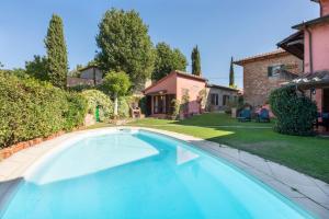 una piscina en un patio con una casa en Villa Rosina, en Lucignano