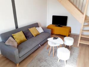 Sala de estar con sofá gris y mesa en La MAIS'ANGE - Charmante maison proche centre, en Blois