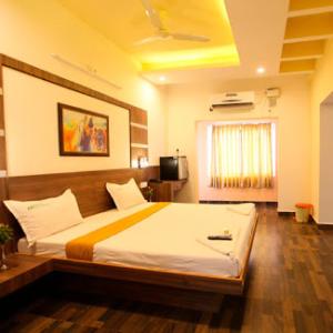 a bedroom with a large bed in a room at Hotel Emerald Regency in Putuppalli