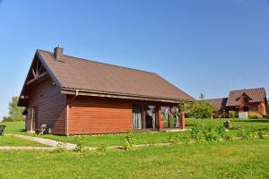 una gran casa de madera en un campo de hierba en Spacious Loft in the Nature, en Molėtai