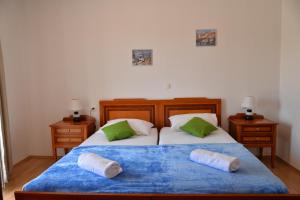 1 dormitorio con 2 camas y almohadas verdes y blancas en Apartments Gera, en Dubrovnik