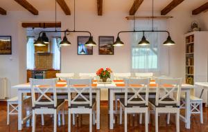 uma sala de jantar com uma mesa branca e cadeiras em Villa Szalamandra - a Tisztás em Matraalmas