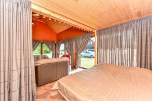 a bedroom with a bed and a couch and windows at Spacious Loft in the Nature in Molėtai