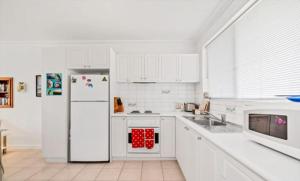 a kitchen with white cabinets and a white refrigerator at Island Villas Accommodation Unit 4-108 Arcadia Drive Shoalwater in Safety Bay