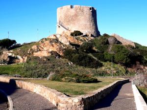 un castillo en la cima de una colina con una carretera en La Residenza Poseidone, en Santa Teresa Gallura
