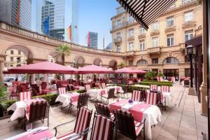a restaurant with tables and chairs and umbrellas at Steigenberger Icon Frankfurter Hof in Frankfurt